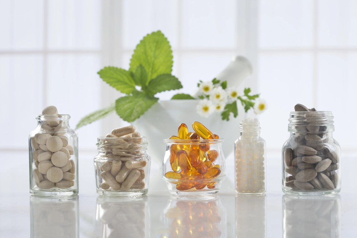 Herbal medicine pills and mortar over bright background Alternative health care fresh herbal ,dry and herbal capsule with mortar