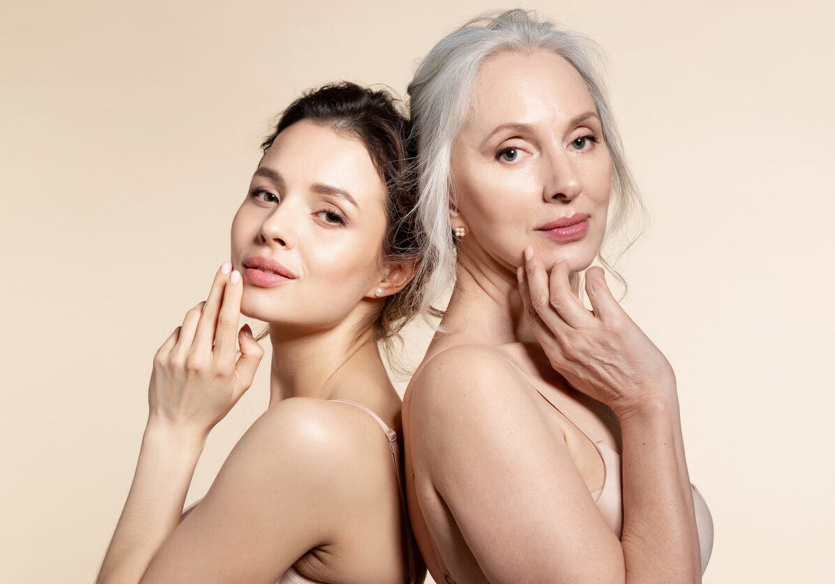 Portrait of senior and young woman Elderly and young women with smooth skin and natural makeup standing back-to-back. Thinking, planning, dreaming
